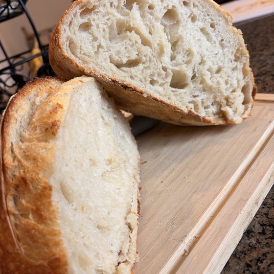 Two halves of a sourdough loaf showing an open, airy crumb.